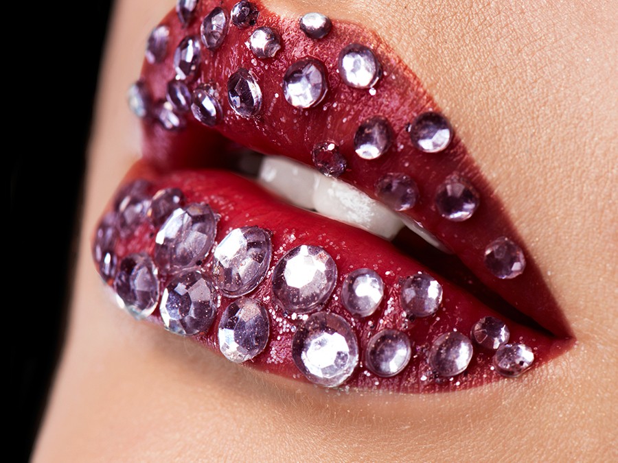 Leicht geöffnete knallrote Lippen, besetzt mit kleinen Kristallsteinen